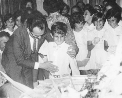 Foto de 1970, de uma solenidade realizada no Salão Nobre do Instituto de Educação “Antônio Justino Falleiros”, quando o aluno Renato Chaebub Rodrigues (“Tim”), recebia o Livro do Ano (que eram entregues aos alunos no final do ano letivo), pelo diretor da escola - José Ignácio de Azevedo Filho. (1) Renato Chaebub Rodrigues (“Tim”), que tinha 7 anos, (2) José Ignácio de Azevedo Filho e, (3) de costa, a professora Ivete Mendonça Soares de Oliveira